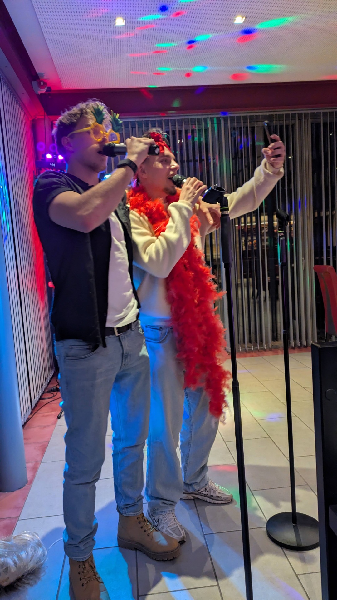 Zwei Kollegen singen Karaoke bei einer Firmenfeier in Wien